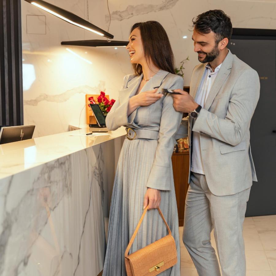 Hotel Pupin 诺威萨 外观 照片 A man helping a woman with her coat